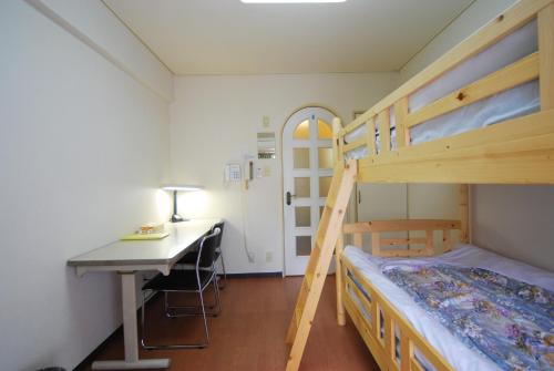 a bedroom with a desk and a bunk bed and a desk at Weekly Green In Namba in Osaka