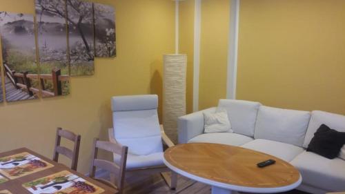 a living room with a white couch and a table at Ferienwohnung Altstadt Löbau in Löbau