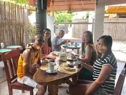 a group of people sitting at a table at Guanna's Place Room and Resto Bar in Malapascua Island