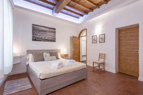 um quarto com uma cama e uma cadeira em Santa Croce Place em Florença