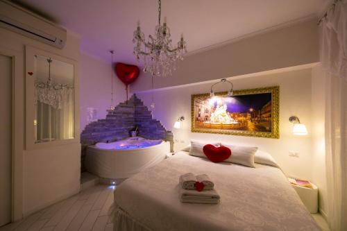 um quarto com uma banheira e uma cama com dois corações em Suites Roma Tiburtina em Roma