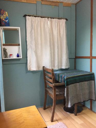 a room with a chair and a window with a curtain at Leo's Den in Fish hoek