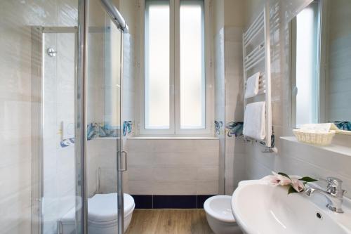 a bathroom with a shower and a sink and a toilet at Hotel Montreal in Florence