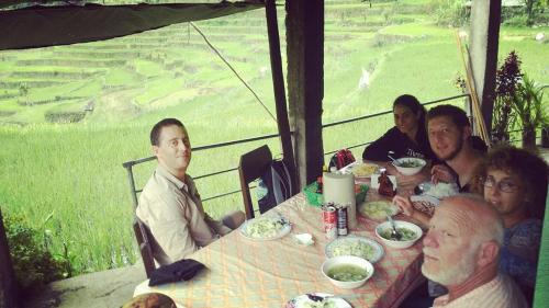 a group of people sitting at a table eating food at BATAD CRISTINA'S Main Village INN & Restaurant in Banaue