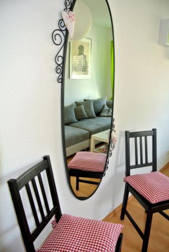 a mirror in a living room with a couch and two chairs at Ferienwohnung Voelkel mit Dachterrasse in Trier
