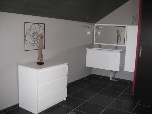 baño con armarios blancos y lavamanos en en gaume séjour au calme en Jamoigne