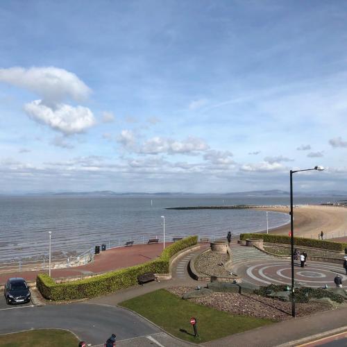 a view of the beach and the ocean with a street light at Morecambe sea view apartment 203 in Morecambe