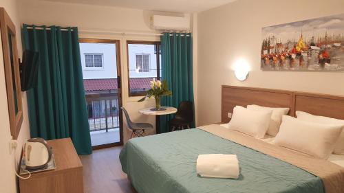 a hotel room with a bed and a window at Manoli Apartments in Ayia Napa