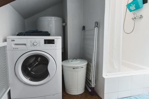 lavadero con lavadora y cubo de basura en 2 Charmants logements * CHARMANT GITE COLMAR *, en Colmar