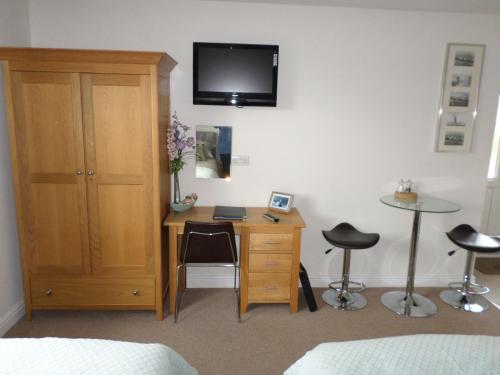 a bedroom with a desk and a tv on a wall at Ramsley Fields Apartments, Melbourne View in Melbourne