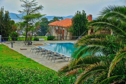 a swimming pool with lounge chairs and a house at Villa Alba Chiara in Ouranoupoli