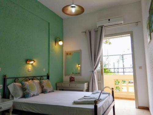 a bedroom with a bed with a green wall at Orion Apartments in Malia