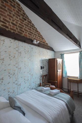 a bedroom with a bed and a brick wall at St Athans Hotel in London