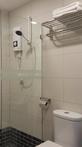 a bathroom with a glass shower with a toilet at Kampar Boutique Hotel in Kampar