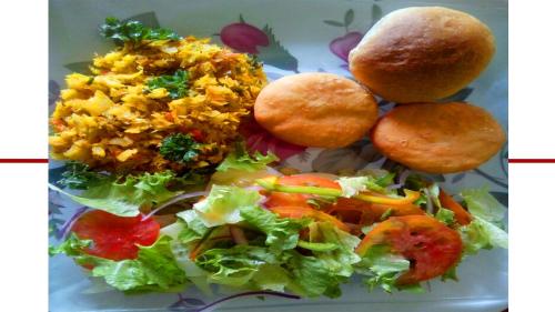 a plate of food with rice and vegetables and bread at Sunset Lane in Laborie