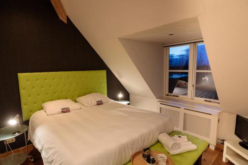 a bedroom with a large bed and a window at 't VeerHuys in Beusichem