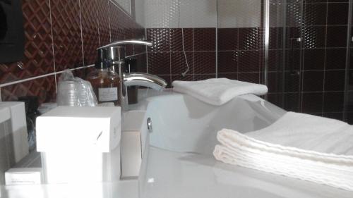 a bathroom with a sink and a faucet with towels at Hotel I Narcisi in Siniscola