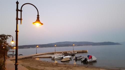 a street light next to a dock with boats in the water at Aloe Apartments Ammouliani in Ammouliani