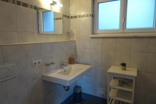 ein weißes Bad mit einem Waschbecken und einem Fenster in der Unterkunft Frozen Time Apartments in Flachau