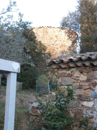 a stone house with a stone wall and trees at La Maison des Oliviers in Cogolin