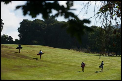 a group of people walking on a field with surfboards at Mains of Taymouth Country Estate 5* Gallops Apartments in Kenmore