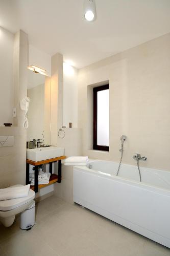 a bathroom with a tub and a toilet and a sink at Arce Boutique in Braşov