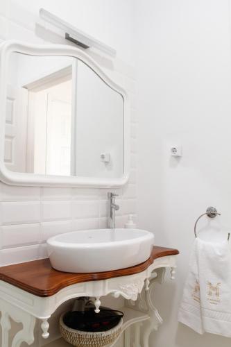 a white bathroom with a sink and a mirror at 3 Marias Residence in Viana do Castelo