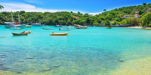 un grupo de barcos en el agua en una playa en Apartamento Centro Búzios, en Búzios