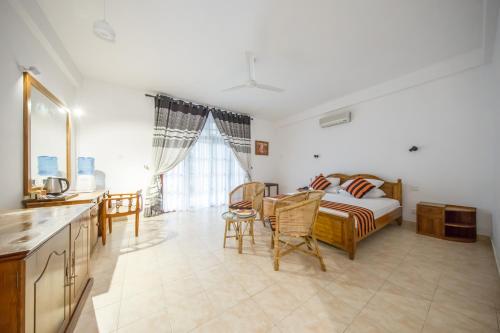 a bedroom with a bed and a table and chairs at Hotel Yapahuwa Paradise in Yapahuwa