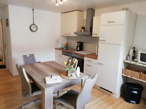 a kitchen with a wooden table and white cabinets at Panorama-Rheinblick St. Goar in Sankt Goar