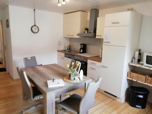 eine Küche mit einem Holztisch und weißen Schränken in der Unterkunft Panorama-Rheinblick St. Goar in Sankt Goar