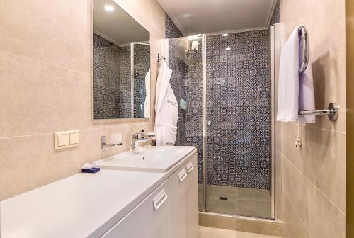 a bathroom with a sink and a glass shower at ZENTRUM Hotel in Chişinău