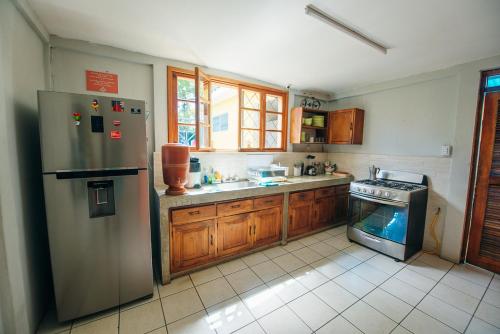 a kitchen with a stainless steel refrigerator and a fish tank at La Bicicleta Hostal in Managua