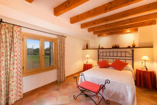 a bedroom with a bed and a red chair at Villa Truc in Pollença