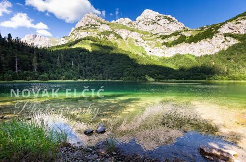 a mountain reflecting in a lake in the mountains at Apartmani Košuta in Tjentište