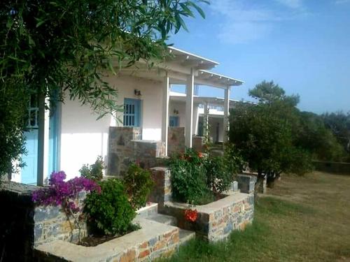uma casa branca com algumas flores em frente em Sunny Studios Naxos em Praia de Aliko