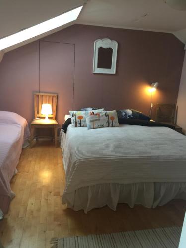 a bedroom with two beds and a table with a lamp at Hotelli Kaivo in Naantali