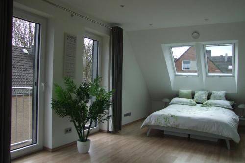 a bedroom with a bed and a potted plant at Im Grüntal in Aachen