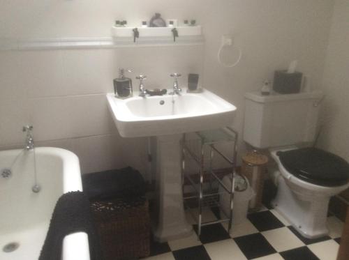 uma casa de banho com um lavatório, um WC e uma banheira em Arden Croft em Pershore