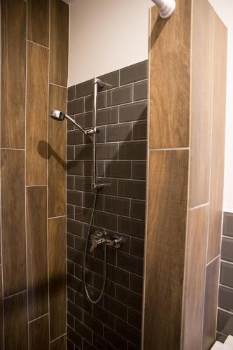 a bathroom with a shower with black tile at Morzsi Apartman in Szilvásvárad