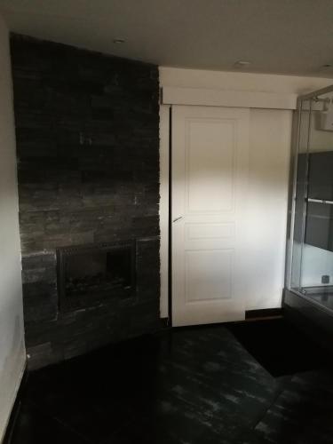 a white door in a room with a brick wall at Le moulin in Pornic