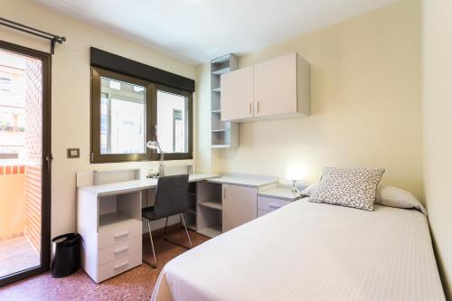une chambre avec un lit, un bureau et un lavabo dans l'établissement ApartUP Mestalla Home, à Valence