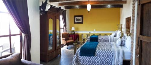 a bedroom with a bed and a yellow wall at Hotel Boutique Posada XVII in Puebla