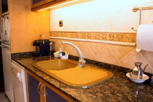 eine Küchentheke mit einer Spüle mit einem Wasserhahn in der Unterkunft Artistic apartment with panoramic views in Canet de Mar