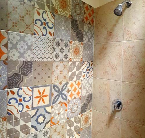 a bathroom with a shower with tiles on the wall at Hotel Boutique Posada XVII in Puebla
