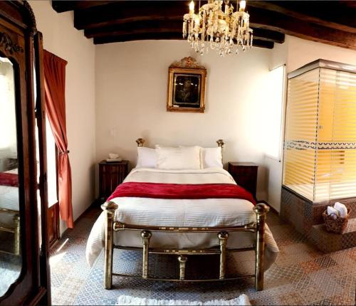 a bedroom with a bed and a chandelier at Hotel Boutique Posada XVII in Puebla