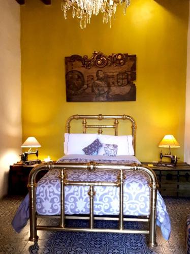 a bedroom with a bed and two tables with lamps at Hotel Boutique Posada XVII in Puebla
