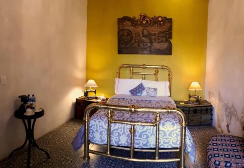 a bedroom with a bed and two tables with lamps at Hotel Boutique Posada XVII in Puebla