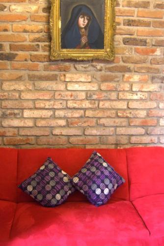 a wall with a painting and two pillows on a couch at Hotel Boutique Posada XVII in Puebla