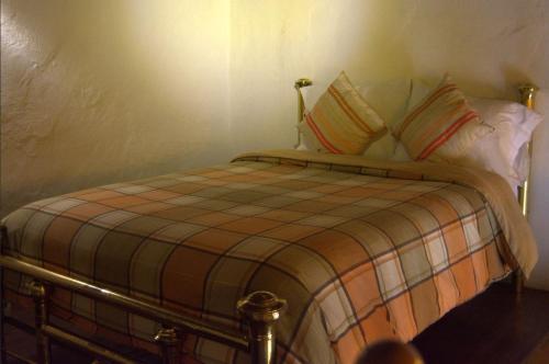 a bedroom with a bed with a plaid blanket and pillows at Hotel Boutique Posada XVII in Puebla